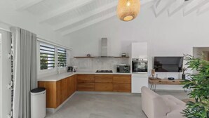 Una cocina moderna con horno empotrado, microondas y estufa a gas.