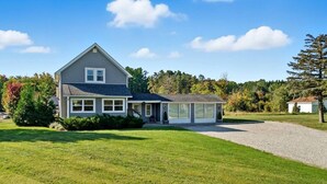 A two-story house with a covered porch, a driveway, and a well-maintained lawn.