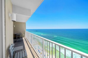 Ein Balkon mit Meerblick, einem Tisch und Stühlen.