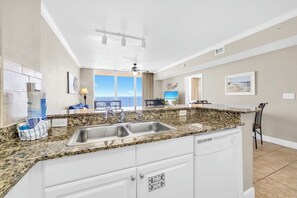 A modern kitchen with granite countertops, a double sink, and a dishwasher. - 🌴Tidewater 2112-Gulf Front-Heated Pool-Hot Tub-Gym and MORE🌴 (Panama City Beach)