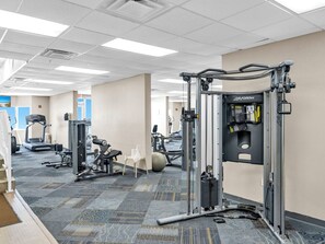 Ein Fitnessstudio mit unterschiedlichen Trainingsgeräten, darunter Laufbänder und Kraftgeräte.