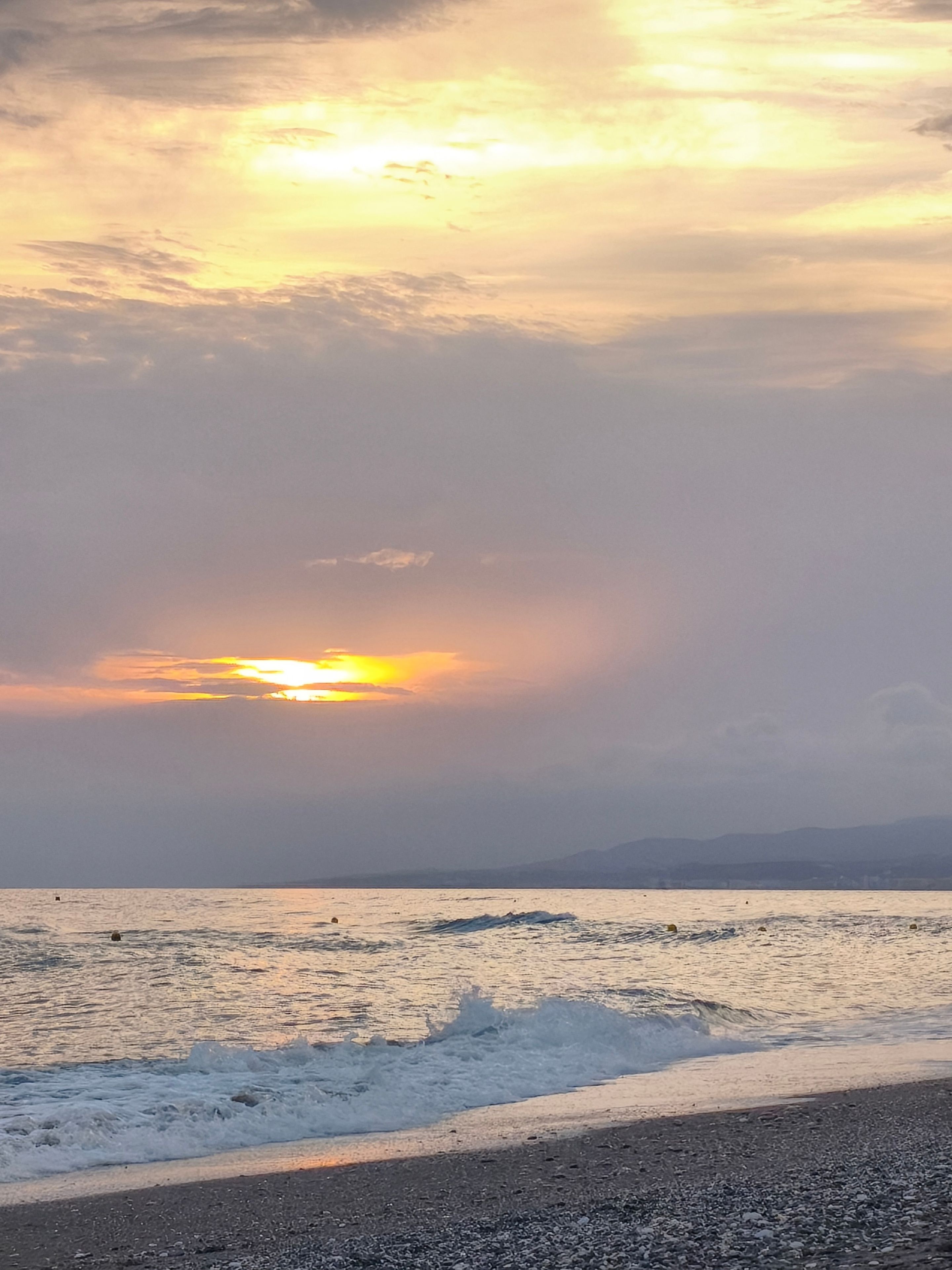 Una platja amb onades i un capvespre.