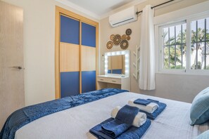 A hotel room with a bed, a vanity with a mirror, and a window with curtains. - Balcón Pueblo Andaluz Apartment with Sea Views, Wi-Fi and Air Conditioning (Torrox)