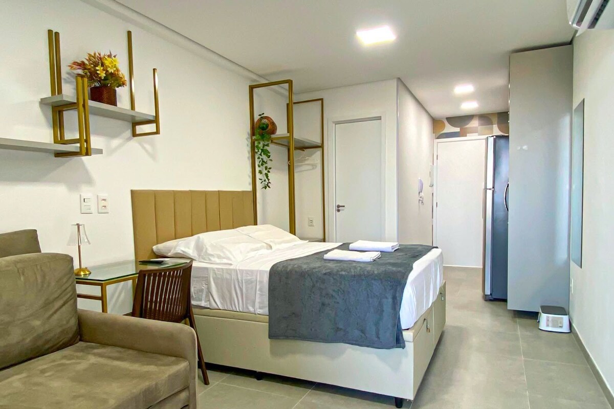 A modern bedroom with a bed, bedside table, and a chair.