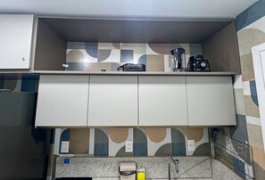 A kitchen with a countertop, a coffee maker, and a sink. - Beach Class Solare por YOLO (Ipojuca)