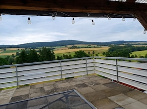 Un balcón con vistas a colinas y campos ondulados.