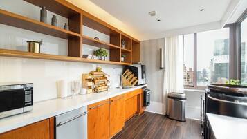 A modern kitchen with wooden cabinets, a built-in microwave, and a large window with a city view.