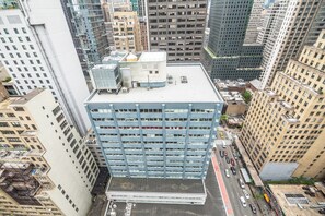 A high-rise building with a flat roof, multiple floors, and a parking lot in front. - Manhattan | Walkable Midtown Escape | Dining & Broadway (NEW YORK)