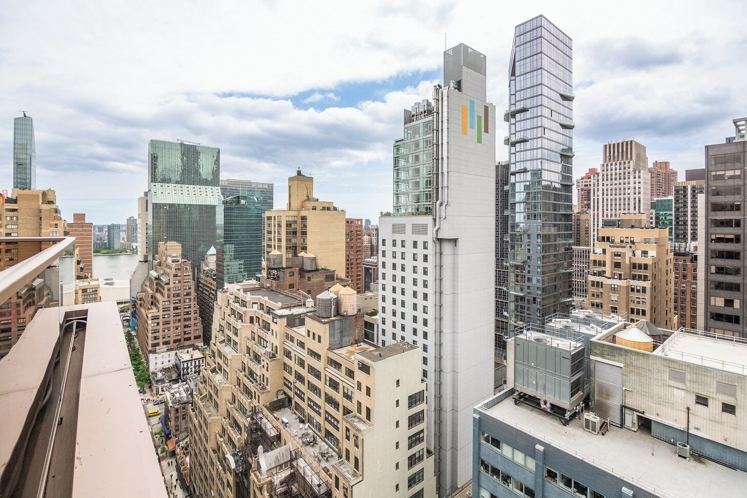 Zona urbana con edificios altos y modernos, incluyendo una torre distintiva con un diseño de líneas verticales.
