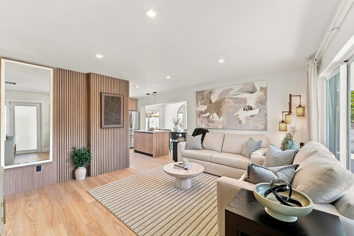Un salon moderne avec un canapé, une table basse et un grand tableau abstrait.