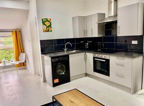 A modern kitchen with a dishwasher, oven, and sink. - Bright, Modern & Comfortable 2-Bedroom Apartment (Manchester)