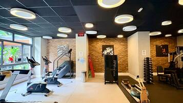 Ein Fitnessstudio mit Laufbändern, Ergometer und Rudergerät.