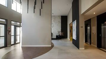 Ein modernes Interieur mit gebogenem Boden, einer Marmorwand und einer Rezeption.