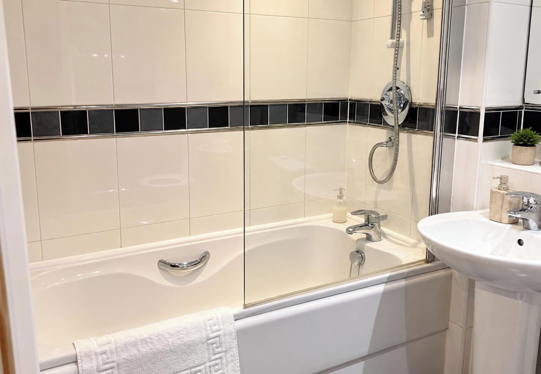 Ein modernes Badezimmer mit Badewanne, Dusche und Waschbecken.