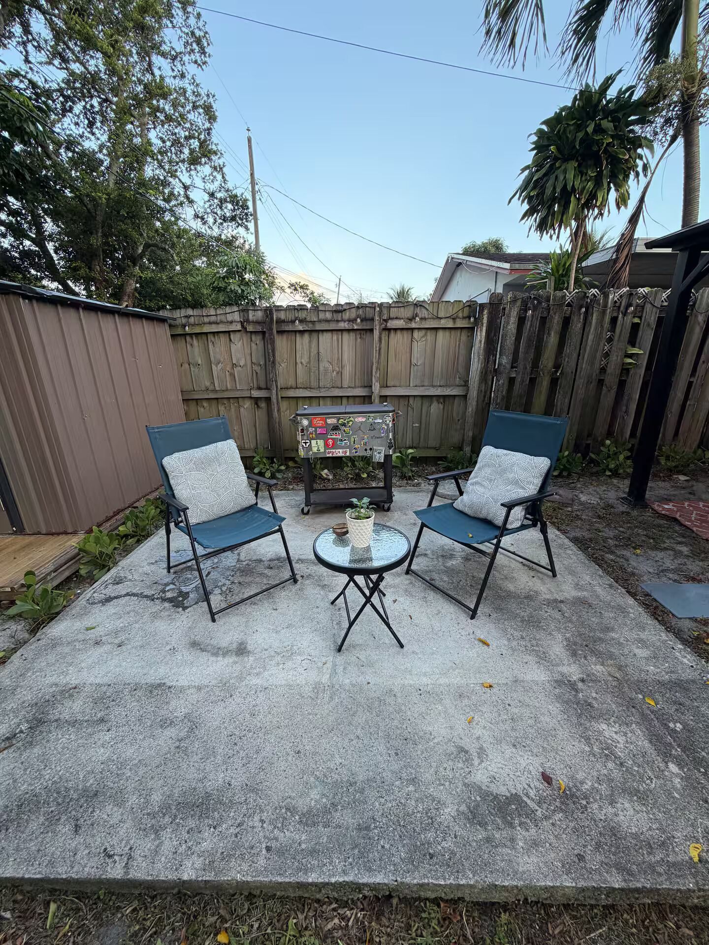 Une terrasse extérieure avec deux chaises et une petite table.