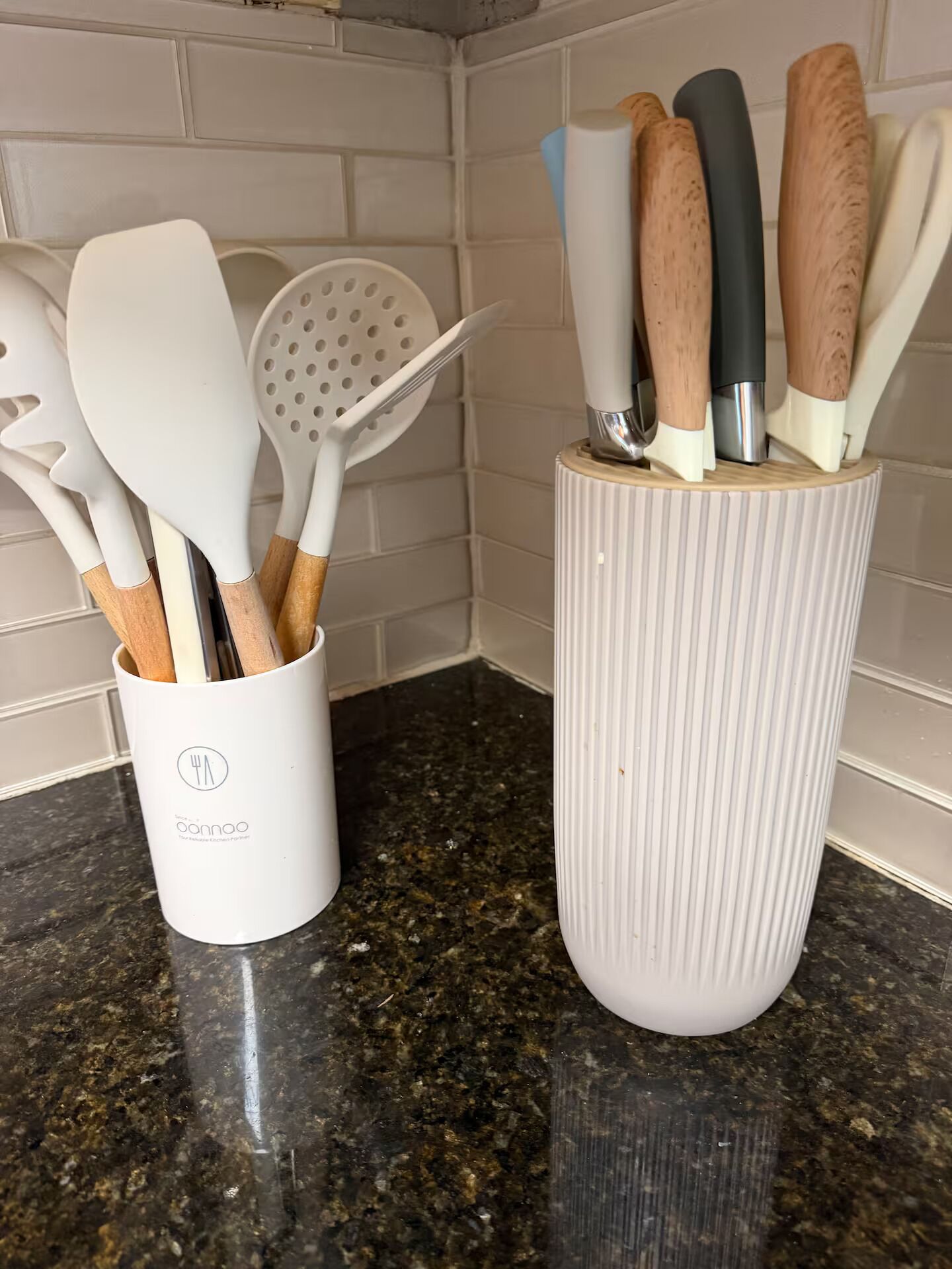 Two kitchen utensil holders with wooden and plastic utensils.