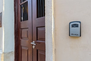 Eine braune Tür mit Schlüsselloch und einem an der Wand daneben befestigten Master Lock.