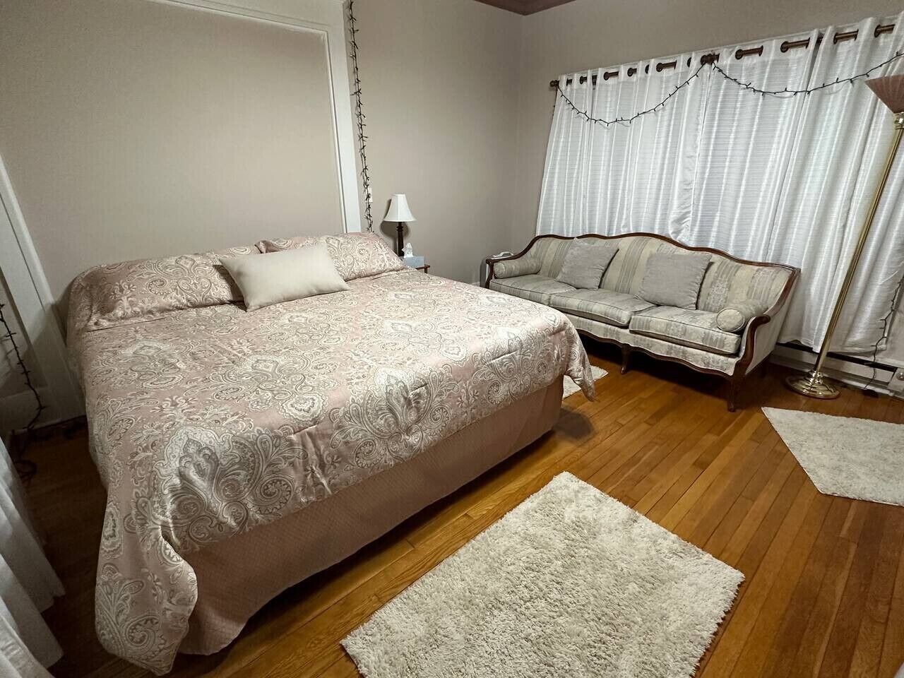 Une chambre avec un grand lit, un canapé et une table de chevet.
