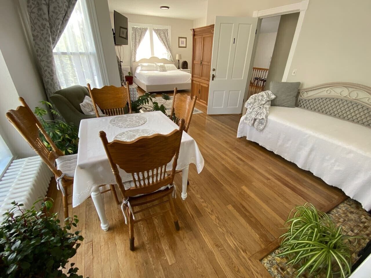 Une pièce comprenant une table à manger, des chaises, un canapé et un lit.