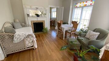 Tunnelmallinen olohuone, jossa on takka, ruokailutila ja mukava istumaryhmä.