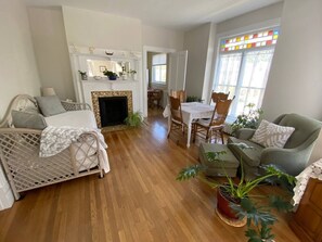 A cozy living room with a fireplace, a dining area, and a comfortable seating arrangement. - Main&Central Suite 1&2 combination (Wellsville)