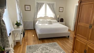 Una camera da letto con un letto, un comodino, una lampada, un termosifone e un armadio in legno.