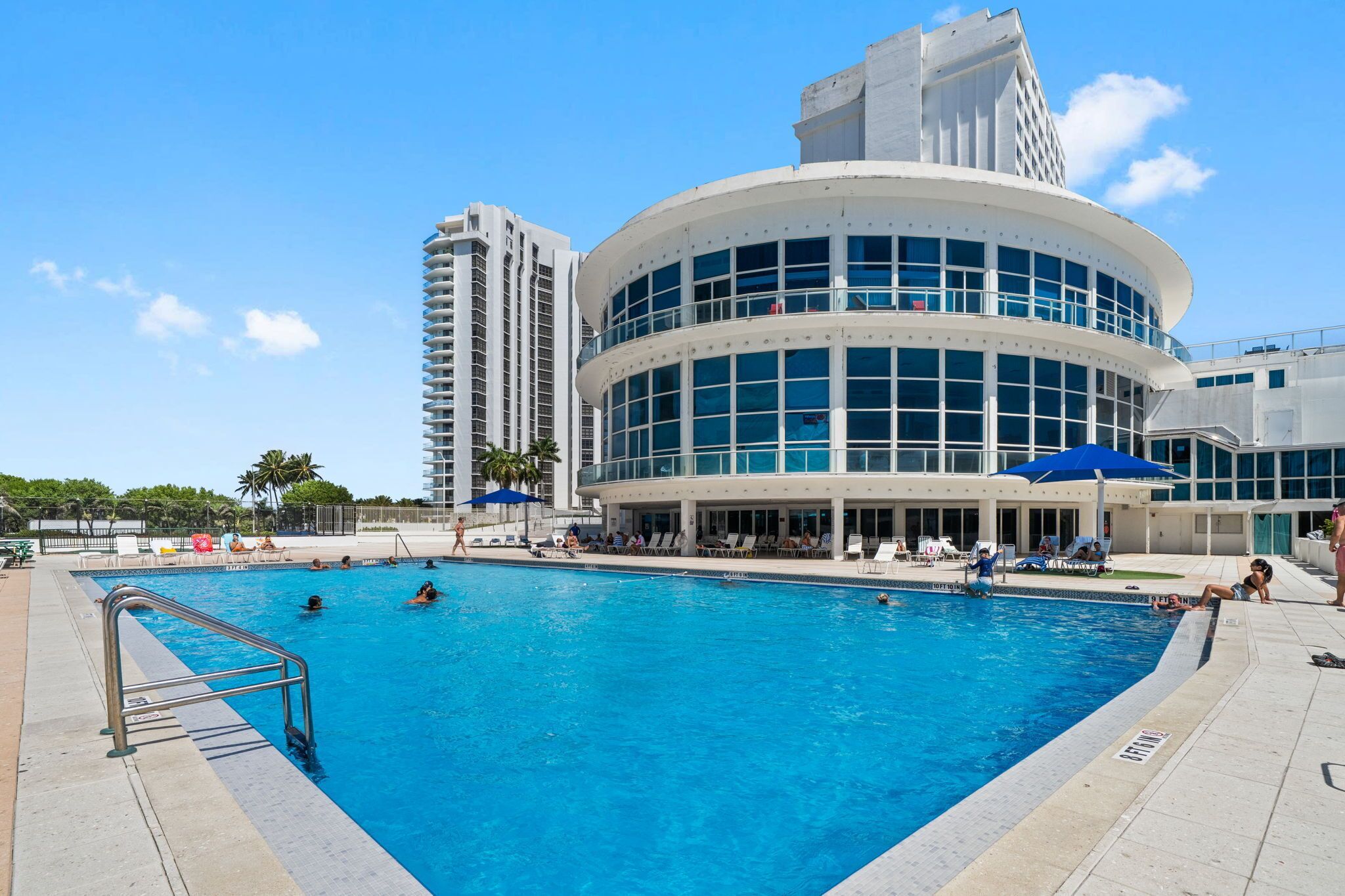 A swimming pool with a modern building in the background.