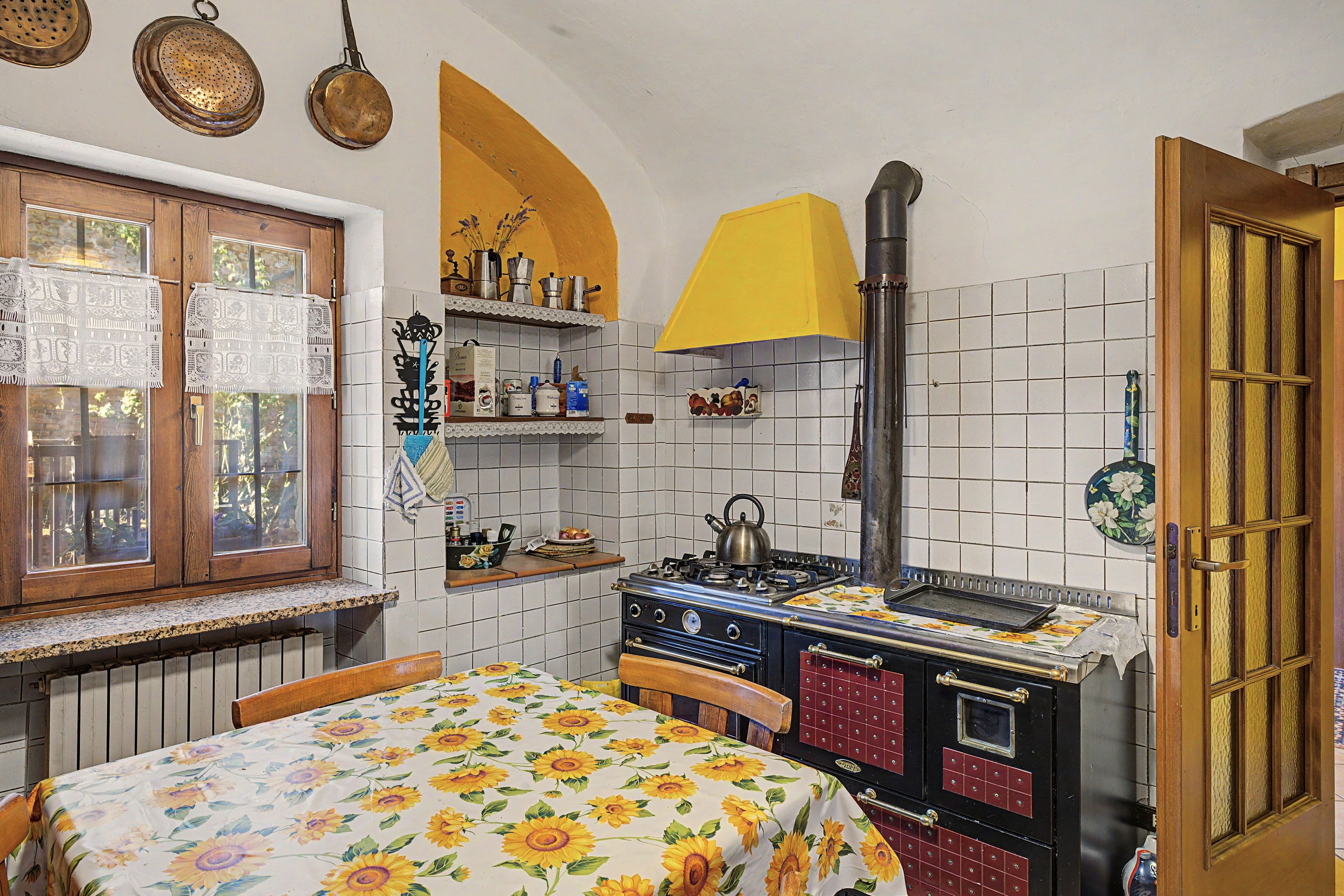 A kitchen with a stove, a window, and a door.