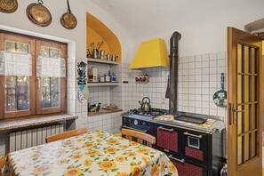 A kitchen with a stove, a window, and a door.