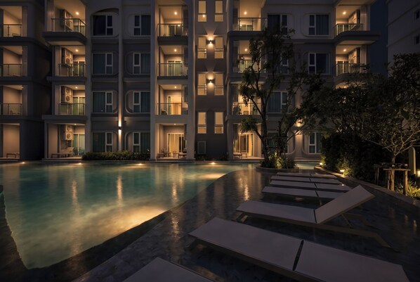 A multi-story hotel with a swimming pool, outdoor seating, and balconies. - Title Serenity Naiyang: pool access (Thalang District)