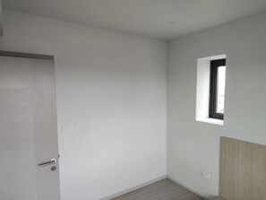 A room with a door, a small window, and a light switch on the wall. - Cozy 2-bedroom apartment at BTS  pho nimit with AC icon Siam (Krung Thep Maha Nakhon)