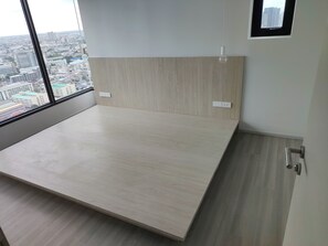 Une chambre dotée d’un grand lit, offrant une vue sur le paysage urbain, et d’une fenêtre donnant sur le panorama.