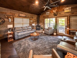 A rustic interior with a leather sofa, a round coffee table, a fireplace, and a ceiling fan. - *NEW* River Valley Retreat ~ directly on White River (Mountain View)