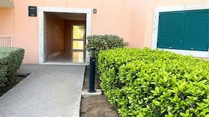 A building entrance with a paved walkway, a hedge, and a door leading to an interior space. - Chic Studio with Pool - Vila Verde (1 to 4 people) (Santa Maria)