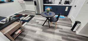 A compact living space with a dining area, a kitchen, and a small seating area. - Daisy's Inn (Saskatoon)