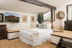 A bedroom with a bed, bedside tables, a dresser, a mirror, and framed artwork on the wall. - Palisades Villa | 360 Views, Hot Tub, Mid-Century (Sedona)