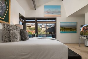 A bedroom with a large bed, a view of mountains, and a painting on the wall. - Palisades Villa | 360 Views, Hot Tub, Mid-Century (Sedona)