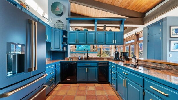 A modern kitchen with blue cabinetry, a central island, and a wooden ceiling. - Palisades Villa | 360 Views, Hot Tub, Mid-Century (Sedona)