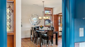A dining area with a round mirror, a chandelier, and a table set with chairs. - Palisades Villa | 360 Views, Hot Tub, Mid-Century (Sedona)