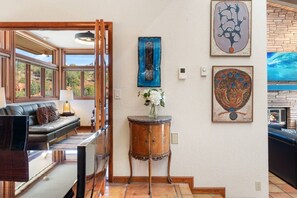 Ein Zimmer mit einer Couch, einem kleinen Tisch mit einer Vase und Bildern an der Wand.