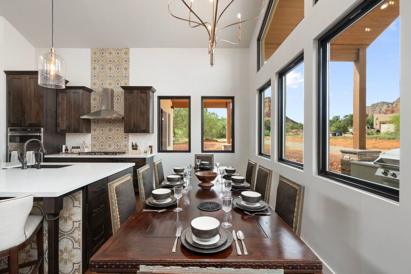 Una cocina moderna con comedor, ventanas amplias y vistas al exterior.