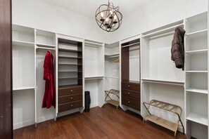 Ein begehbarer Kleiderschrank mit offenen Regalen, Schubladen und einer Kleiderstange.