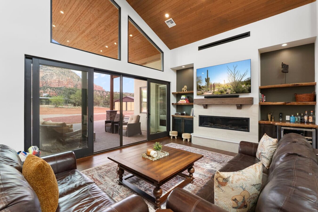 A spacious living room with a large window, a fireplace, and a cozy seating area.