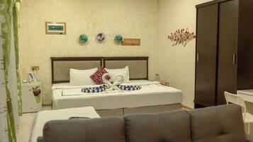 A hotel room with a bed, a wardrobe, a desk, and a chair.
