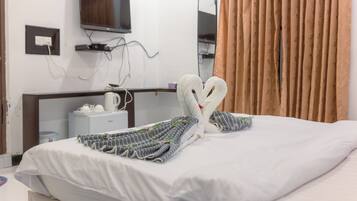 A hotel room with a bed, a television mounted on the wall, and a mirror.