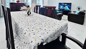 A modern living room with a dining area, featuring a large TV, comfortable seating, and decorative elements. - Apartments - Furnished Condos - Yassa Douala - WILMA HOUSE: Just Like Home (Yassa)