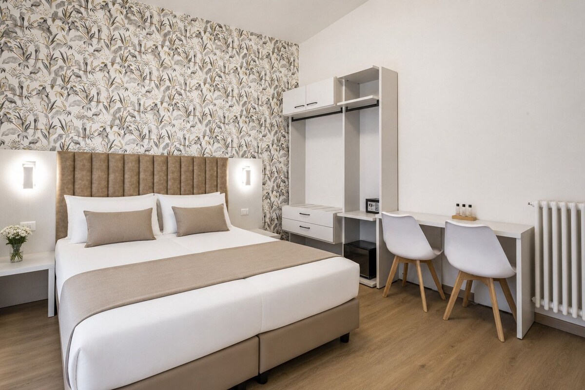 Une chambre moderne avec un grand lit, des tables de chevet, un bureau avec des chaises et un radiateur.