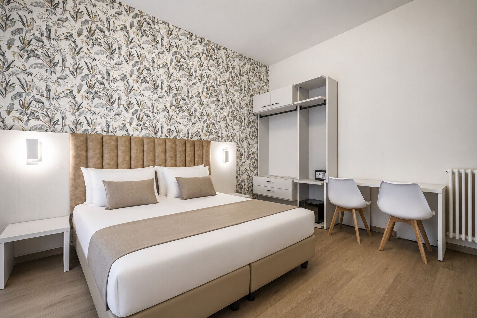 Une chambre à coucher comprenant un lit, des tables de chevet, un bureau avec des chaises et une armoire.
