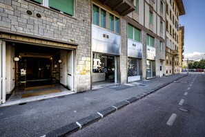 Een straatbeeld van een rij gebouwen met etalages, waarvan sommige borden hebben en andere verduisterd zijn met luiken.
