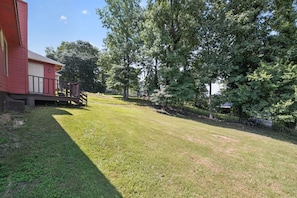 Ein rotes Gebäude mit einer Veranda und einem gepflegten Rasen.